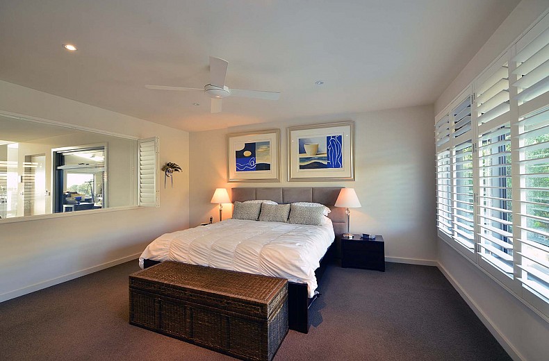 Main bedroom at the rear of the first floor, overlooks the stair and rear pool.  The opening to the left can be shuttered or open to reveal a view of the bay looking right through the upper floor.