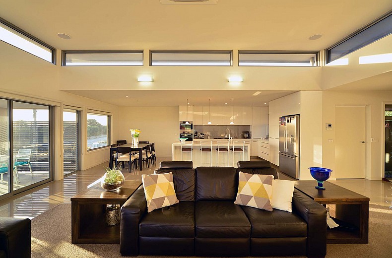 The living area with kitchen and dining behind, raised central roof with 360 degree highlight windows floats above.