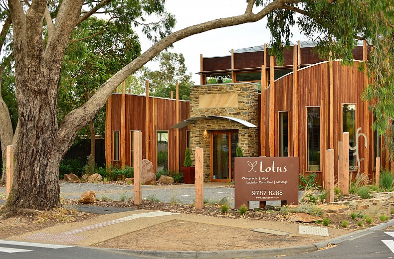 The streetscape shows the building nestled into the existing trees, with a well setback upper storey.