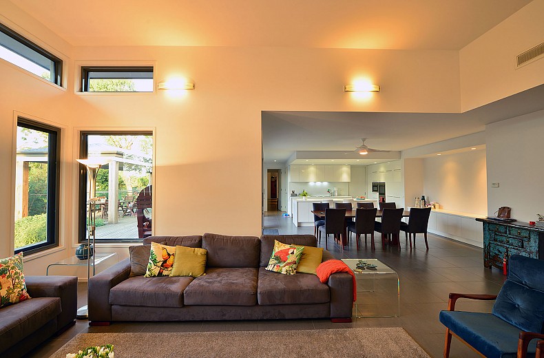The living area links through to the dining and kitchen. The alfresco dining is seen through the window.