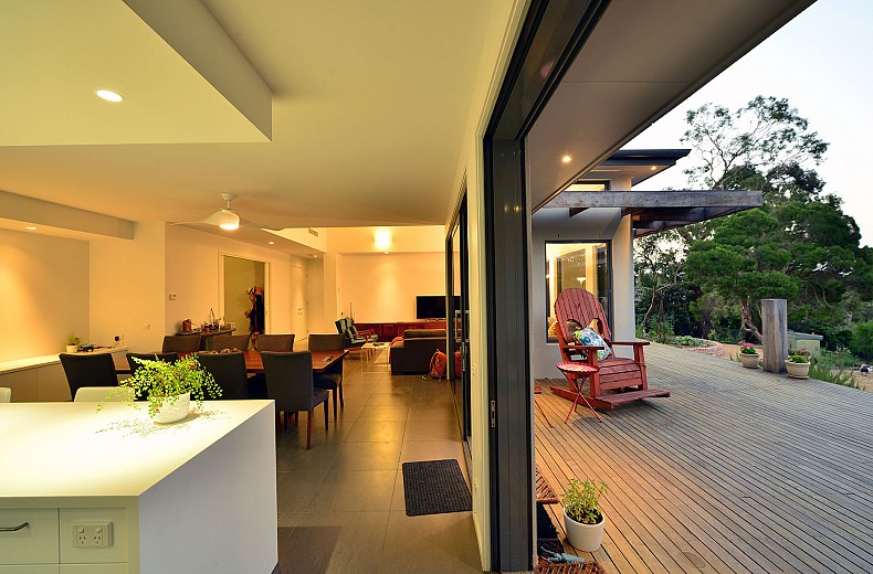 Two sets of multiple sliding doors open onto the deck area from the kitchen and dining room.